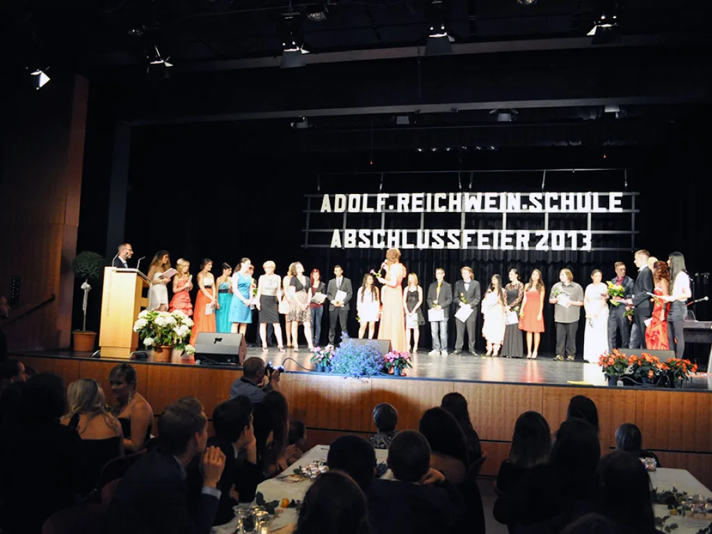 Große Gruppe steht bei der Ehrung auf der Bühne.
